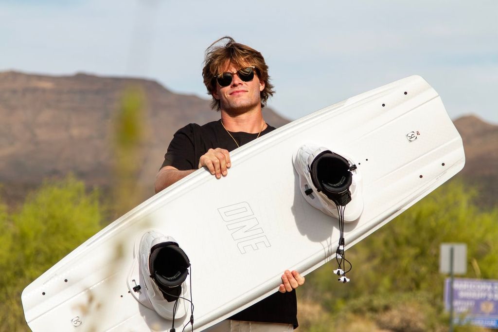 Rider holding a Ronix One Blackout wakeboard